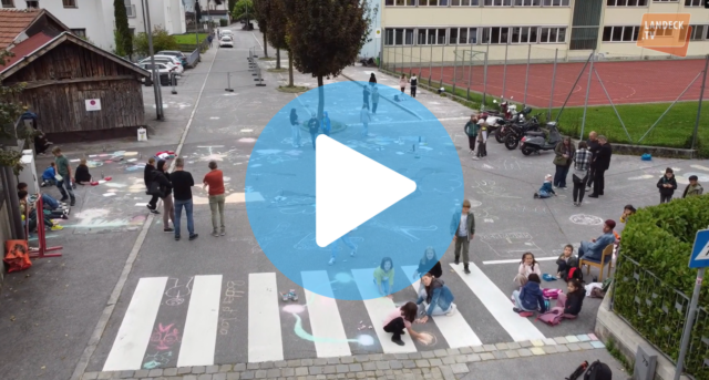 Straße mit Kindern, die sie mit Kreide bemalen. Videovorschau Zeichen darübergelegt